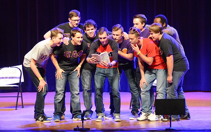 Group of students performing on stage during Greek Sing