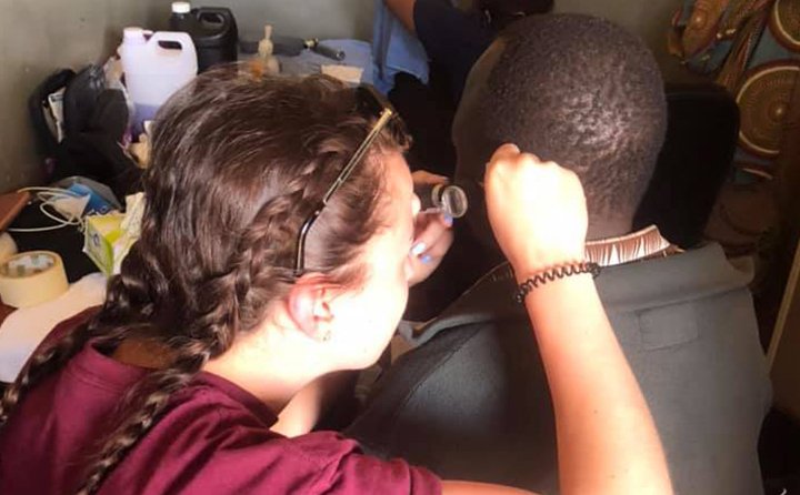 A graduate speech-language pathology graduate student assessing a patient in Zambia.